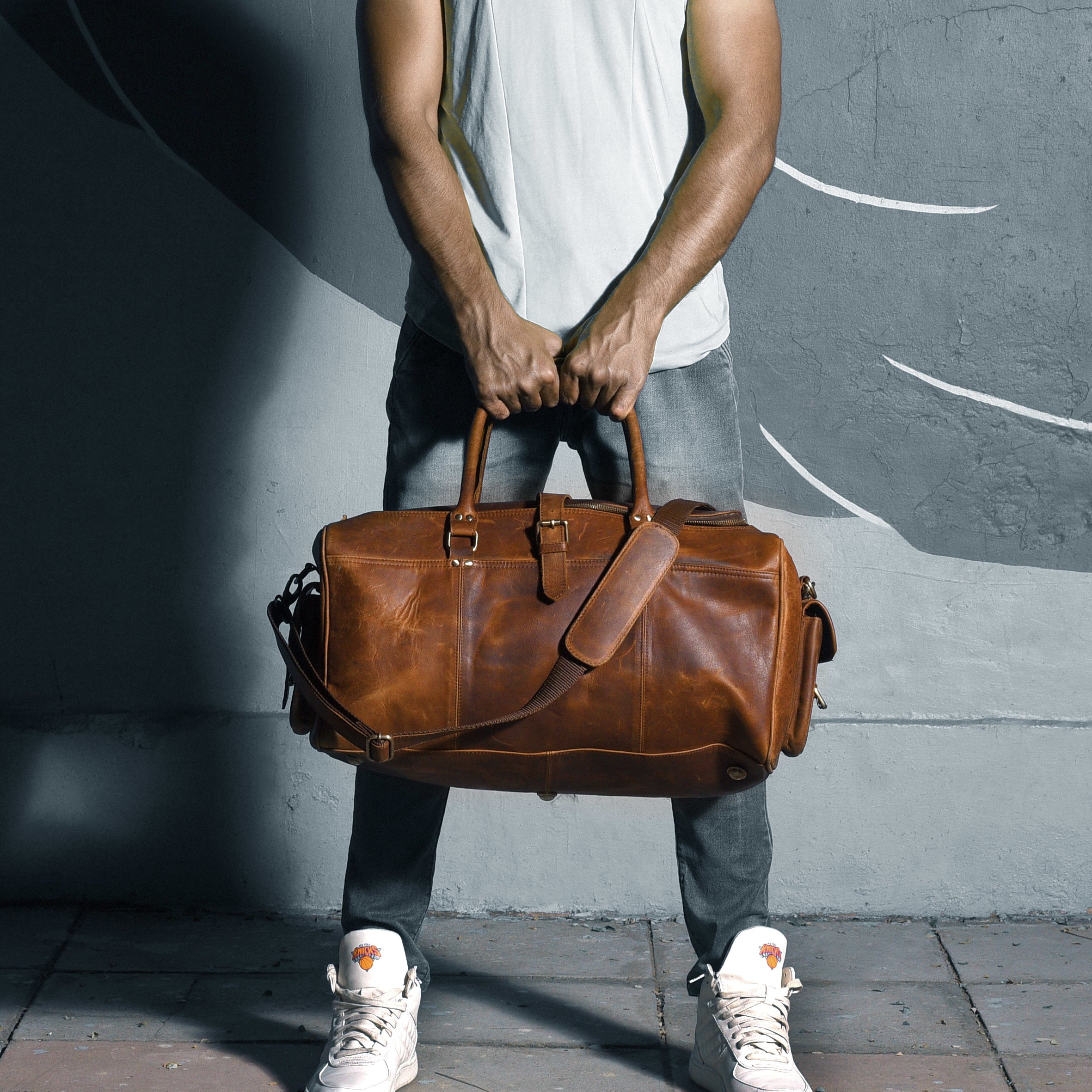 man-holding-his-leather-travel-bag.jpg